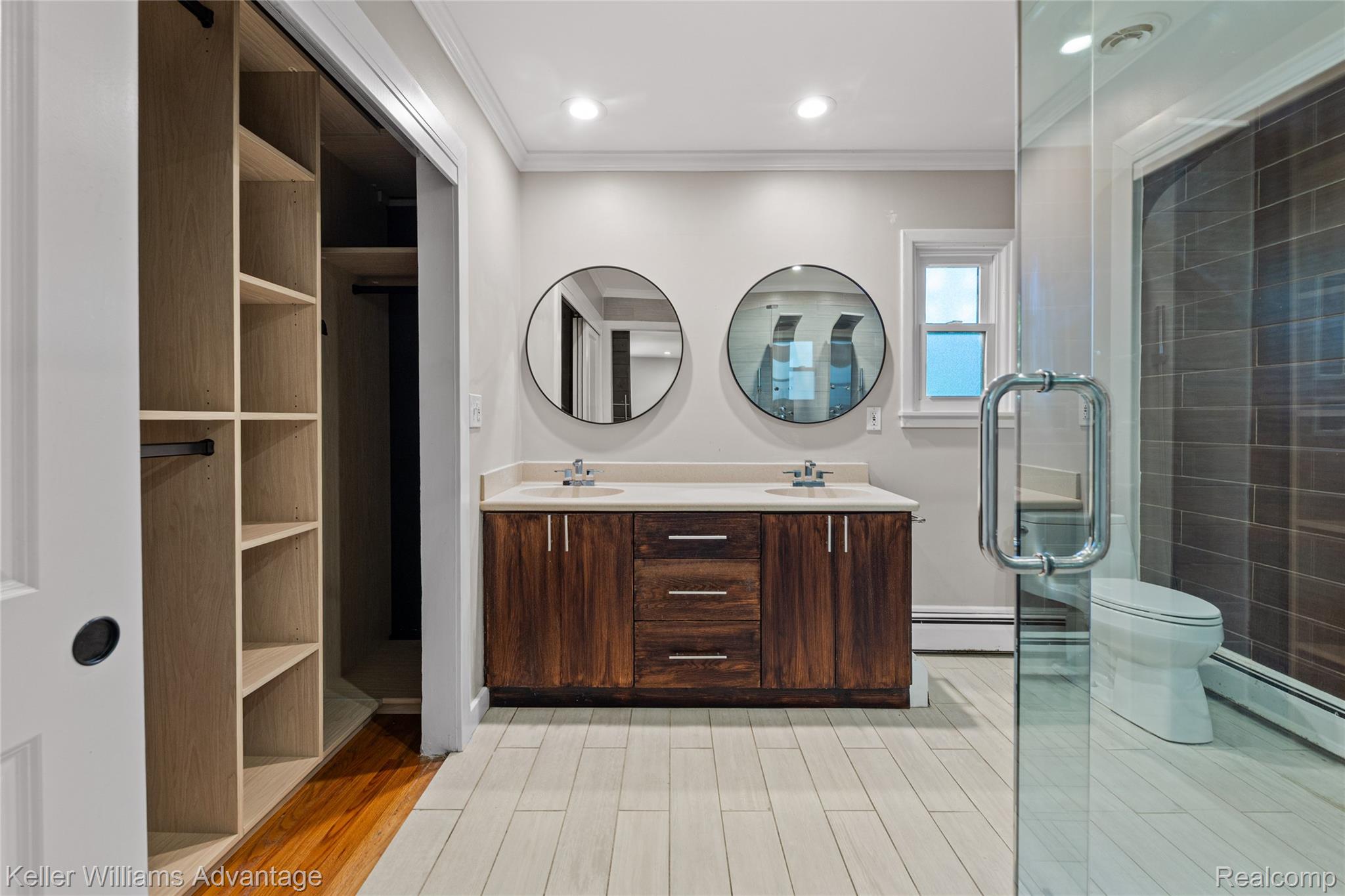 5722 Raven Road Bloomfield Hills, MI 48301 - Photo 24 of 34 Dual vanity with wood-finish cabinetry and round mirrors