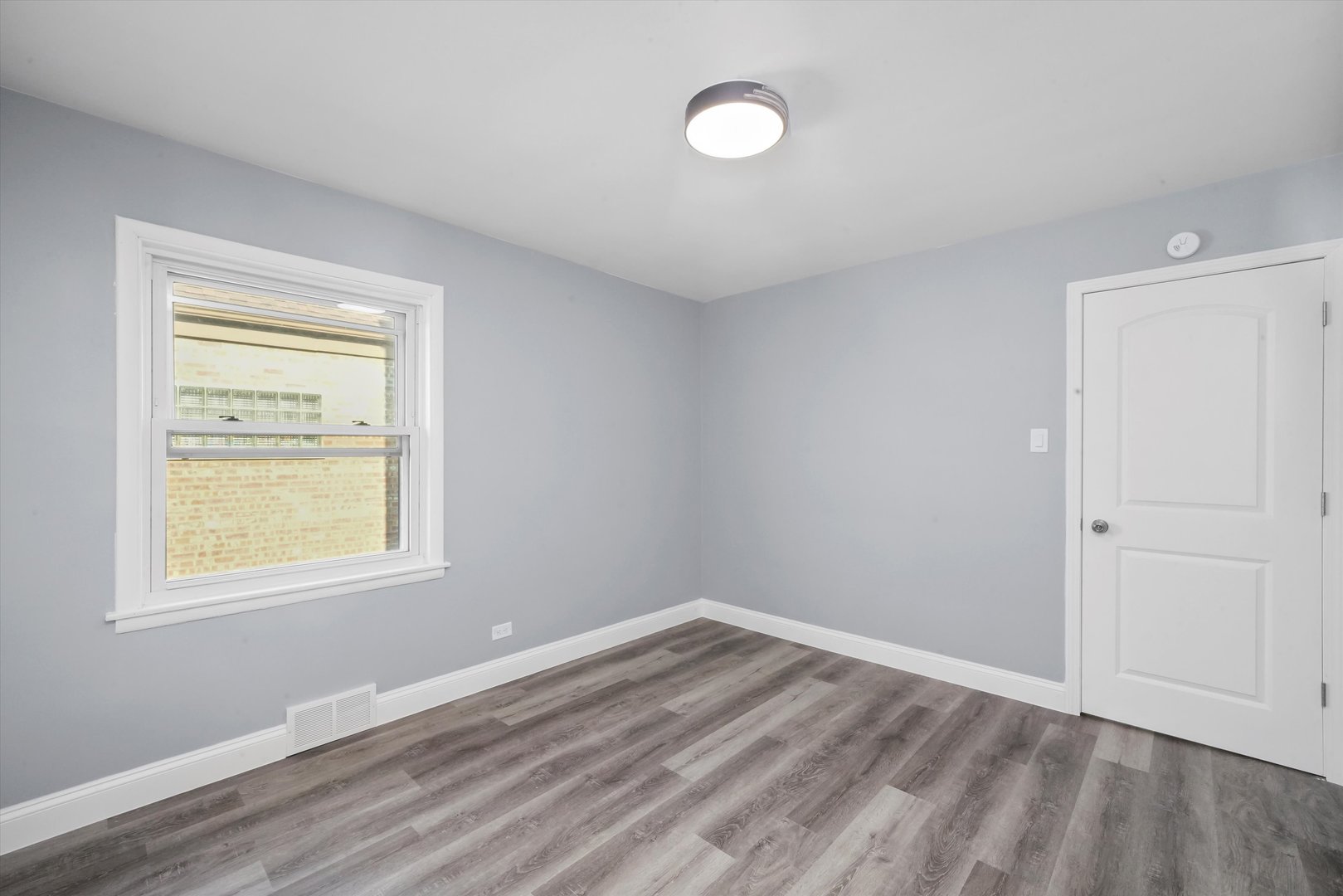 4353 West Marquette Road Chicago, IL 60629 - Photo 21 of 47 a view of an empty room with wooden floor and a window