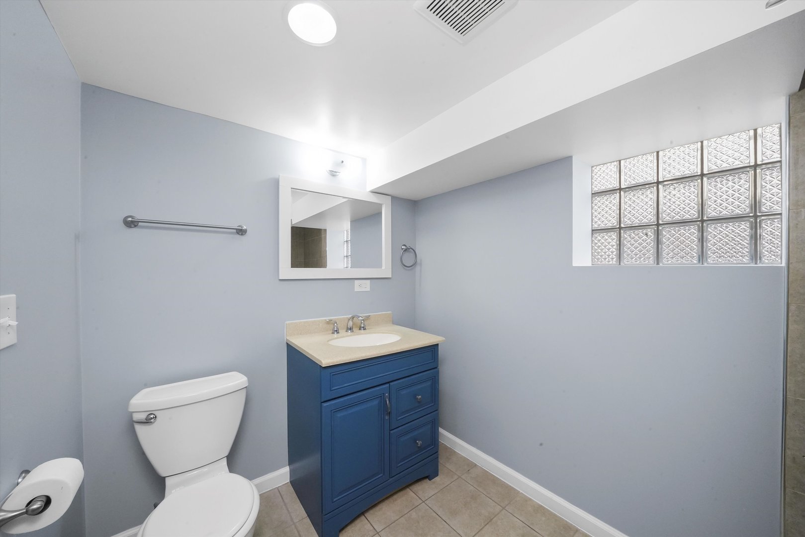 4353 West Marquette Road Chicago, IL 60629 - Photo 32 of 47 a bathroom with a toilet a sink and mirror