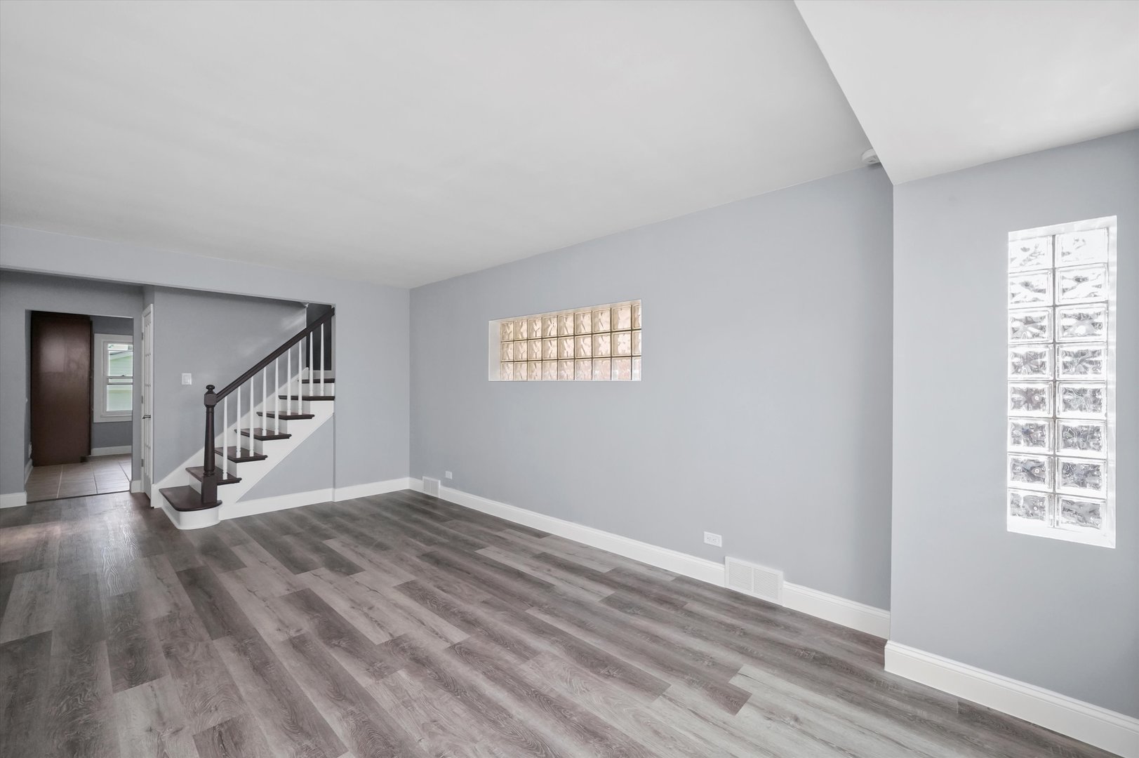4353 West Marquette Road Chicago, IL 60629 - Photo 10 of 47 a view of an empty room with wooden floor and windows