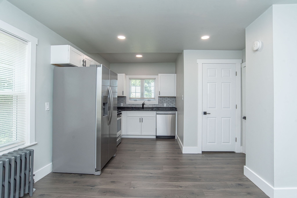 260 High Street Cumberland, RI 02864 - Photo 11 of 42 a kitchen with white cabinets and stainless steel appliances