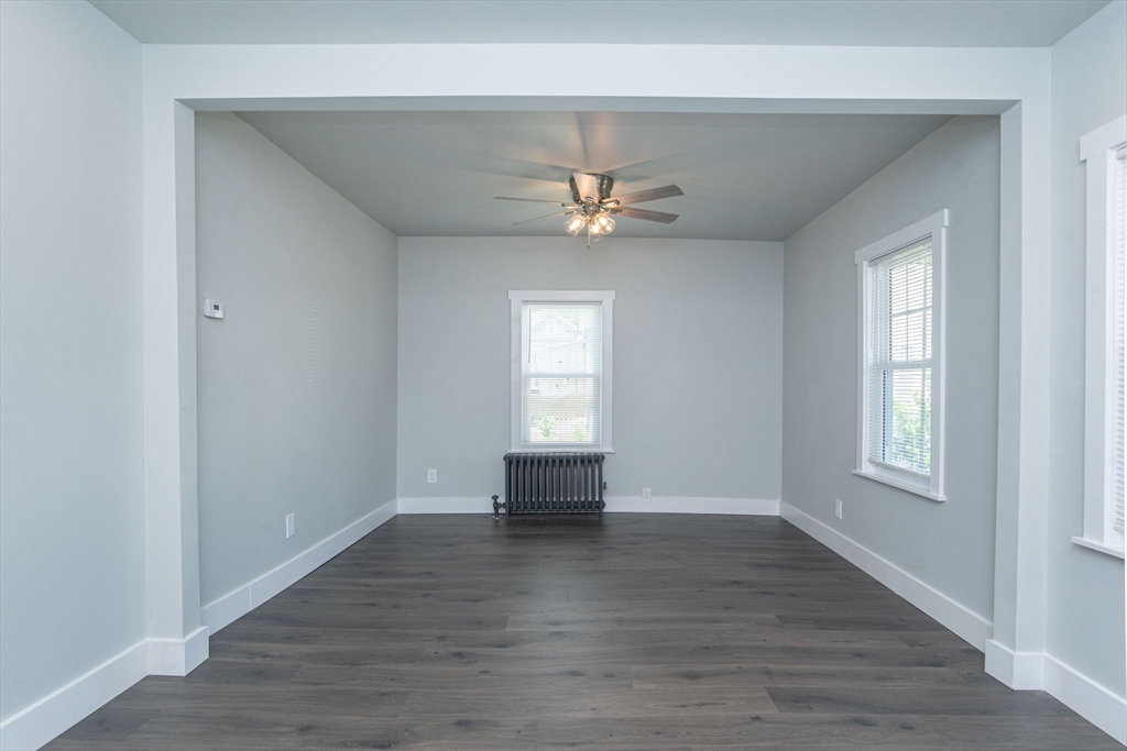 260 High Street Cumberland, RI 02864 - Photo 20 of 42 an empty room with wooden floor chandelier fan and windows