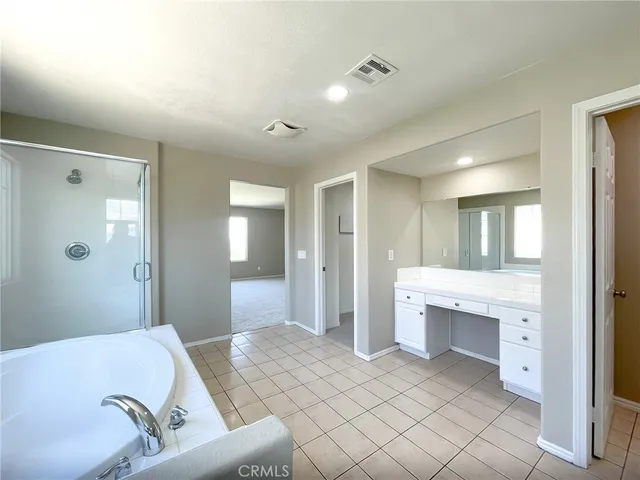 a spacious bathroom with a granite countertop tub sink shower and mirror