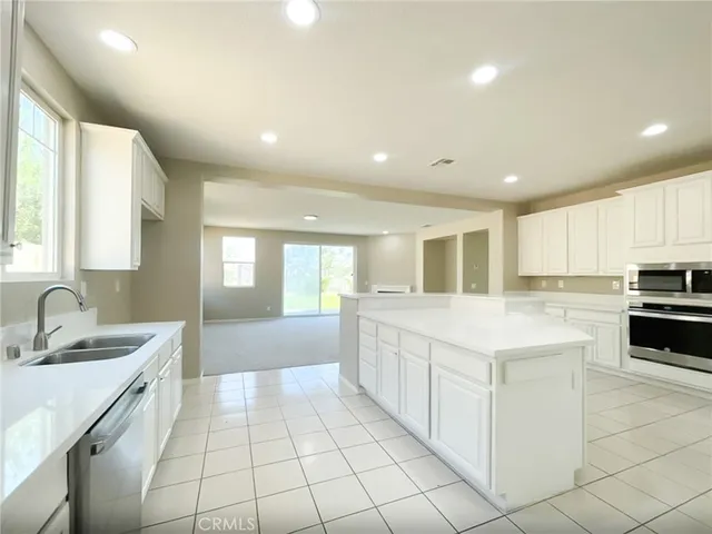 a large white kitchen with a sink and cabinets