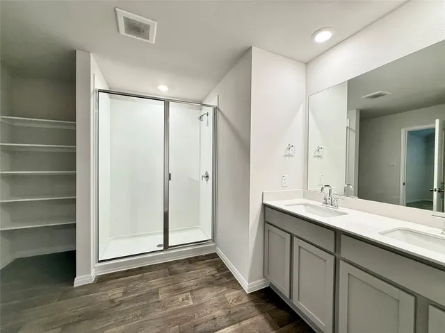 a bathroom with a double vanity sink mirror and shower