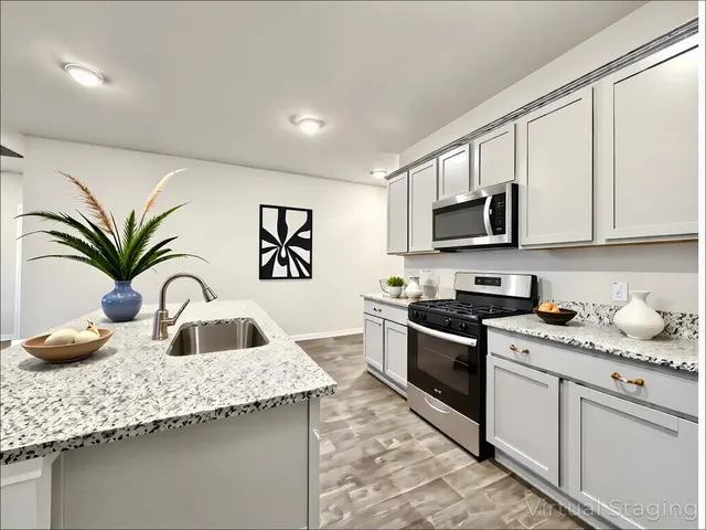 a kitchen with granite countertop a sink a stove and cabinets