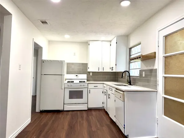 a kitchen with a white cabinets sink and white stainless steel appliances