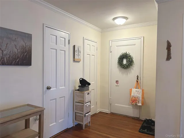 a view of a hallway with wooden floor and closet