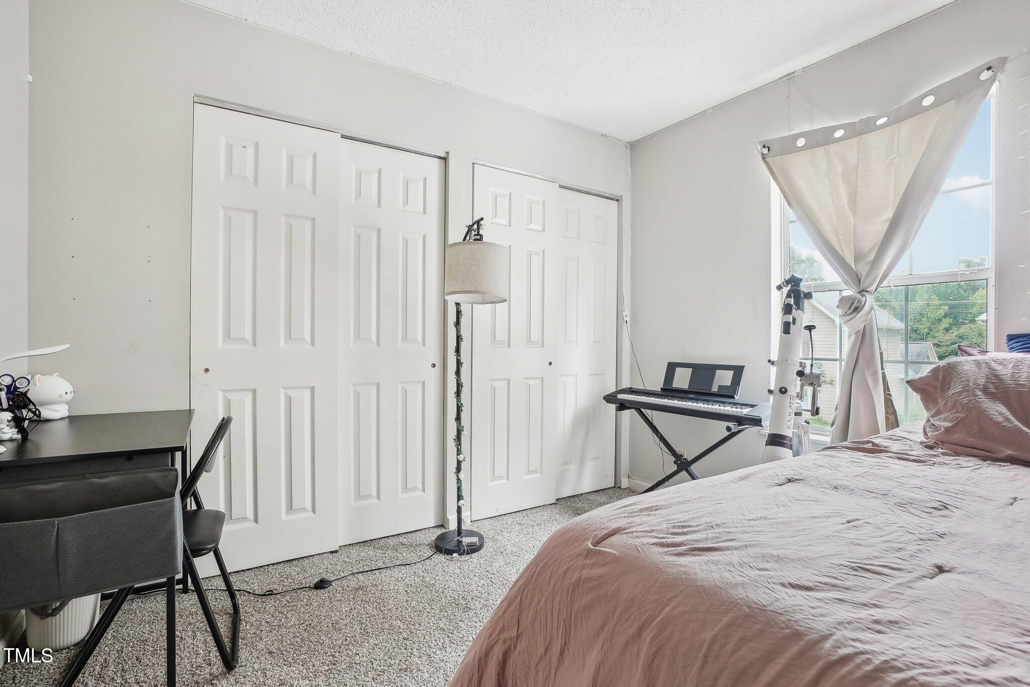 418 Devlin Place Durham, NC 27707 - Photo 17 of 19 a bedroom that has a bed and a table in it