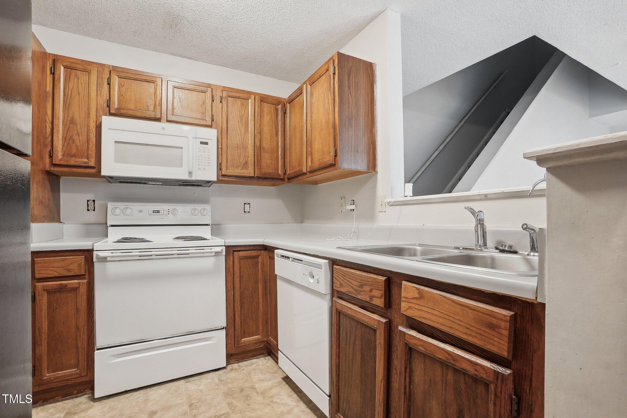 418 Devlin Place Durham, NC 27707 - Photo 8 of 19 a kitchen with stainless steel appliances granite countertop a sink stove and cabinets