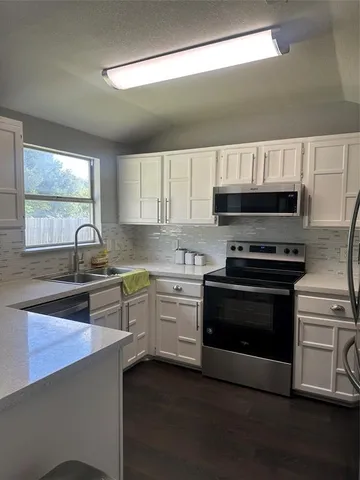 a kitchen with wooden cabinets and a stove top oven