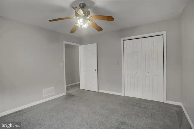 an empty room with chandelier fan