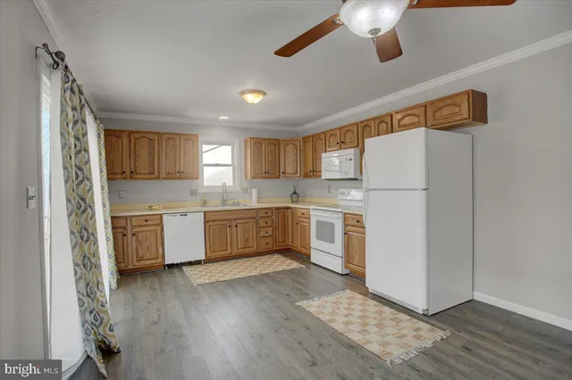 a kitchen with a refrigerator a microwave oven cabinets and wooden floor