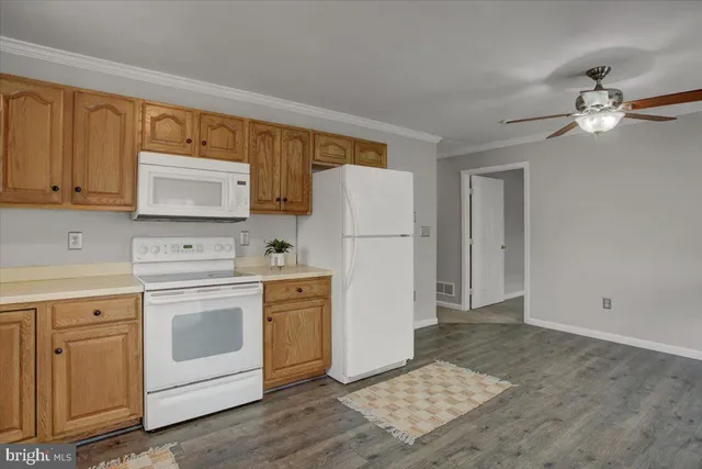 a kitchen with white cabinets and white appliances