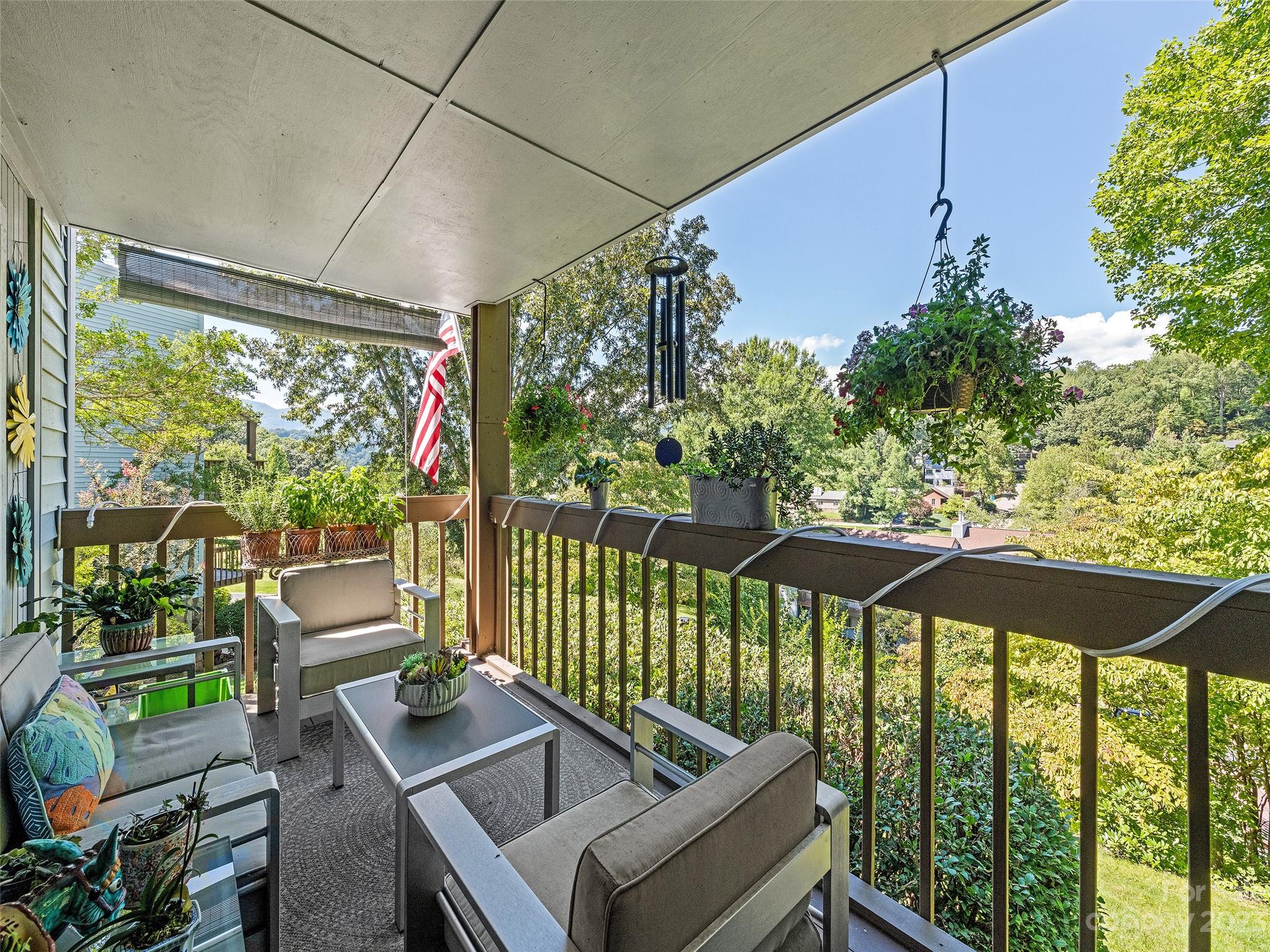87 Willow Road, Unit C1 Waynesville, NC 28786 - Photo 7 of 48 a view of a patio with a table chairs under an umbrella