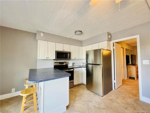 a kitchen with a refrigerator a stove and a sink