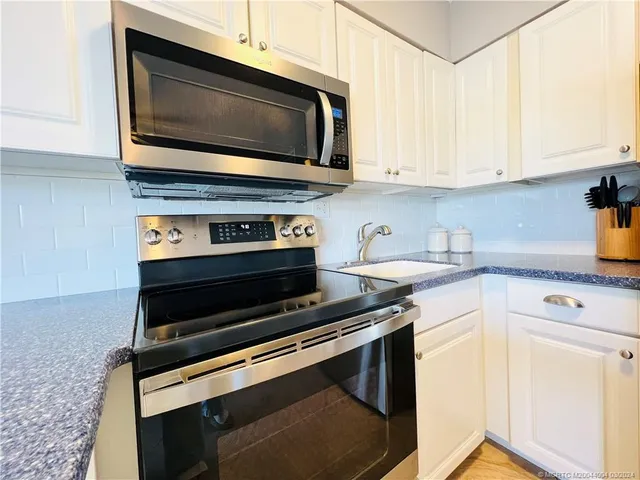 a kitchen with microwave stove and cabinets