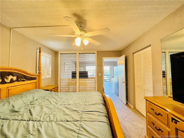 a bedroom with a bed and a flat tv screen on dresser