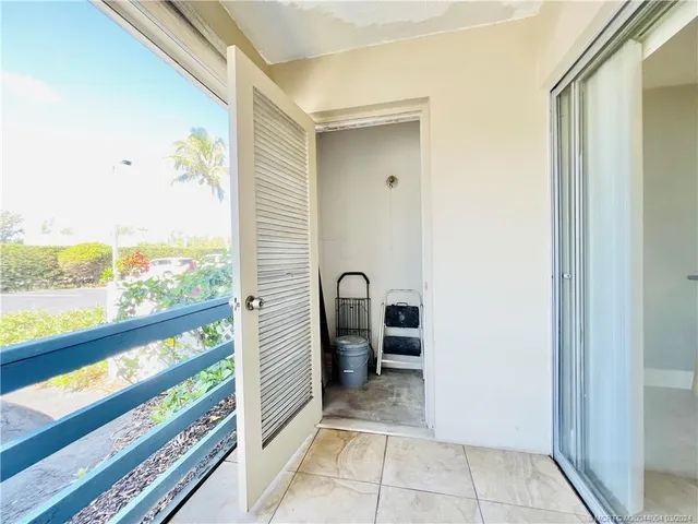 a view of a balcony with furniture and floor to ceiling window