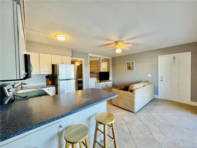 a kitchen with stainless steel appliances granite countertop a sink a stove and refrigerator
