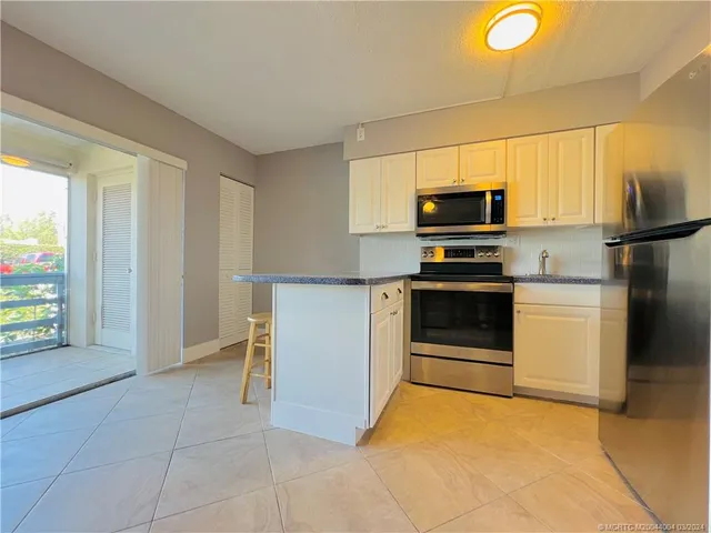 a kitchen with a stove a microwave and a refrigerator