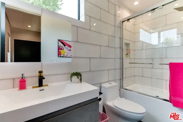 a bathroom with a sink toilet a mirror and shower