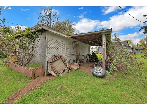 a view of a chair and table in backyard of the house