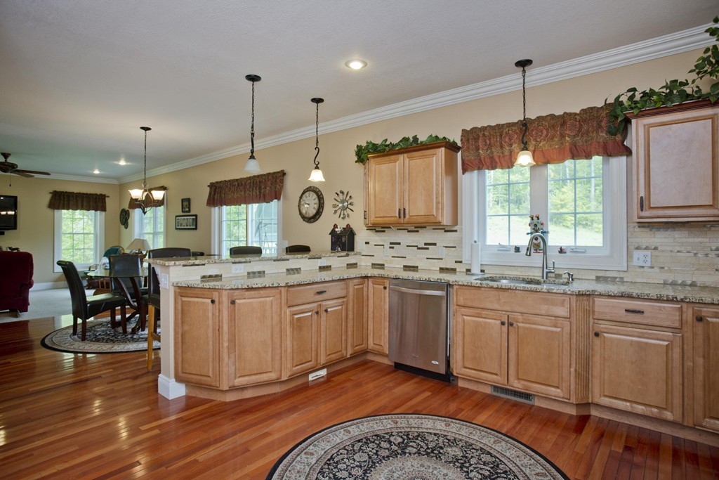 676 Old Warren Road Palmer, MA 01069 - Photo 10 of 30 a large kitchen with granite countertop a stove a sink a window and chairs