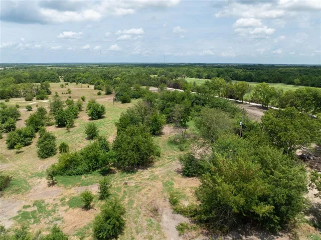 an aerial view of residential houses with outdoor space and trees