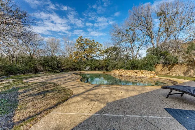 a view of swimming pool with outdoor seating and plants