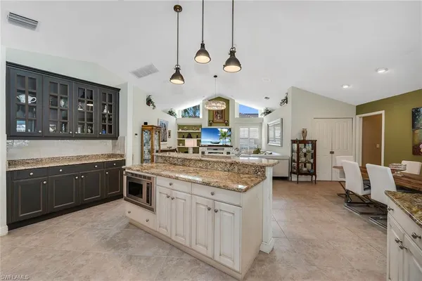 a kitchen with stainless steel appliances granite countertop a stove and a view of living room