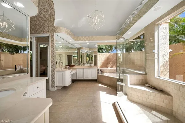 a bathroom with a tub sink and mirror