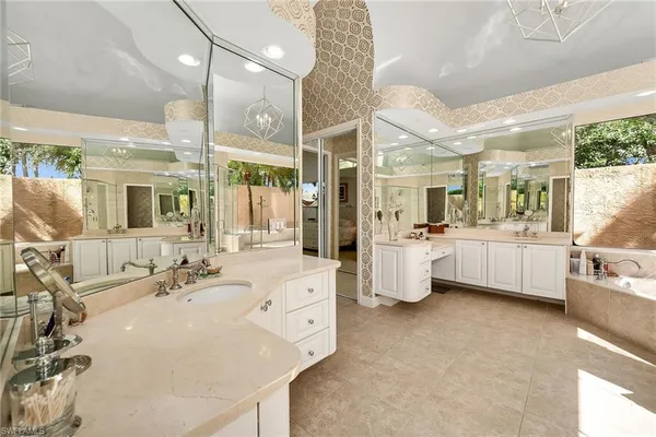 a bathroom with a double vanity sink mirror and bathtub