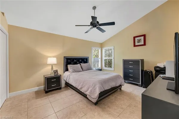 a bedroom with a bed and a flat tv screen on the dresser