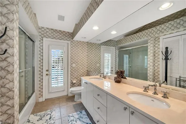 a spacious bathroom with a double vanity sink a mirror and a shower