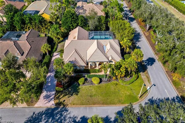an aerial view of a house with swimming pool and trees
