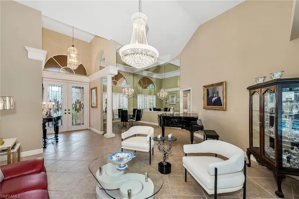 a living room with furniture a chandelier and a large mirror