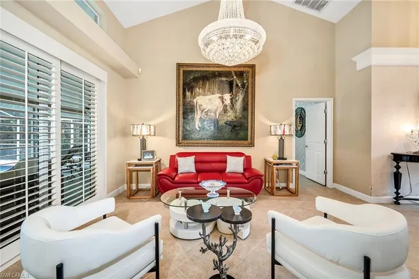 a living room with furniture chandelier and a window