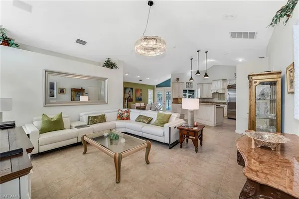 a living room with furniture chandelier and a window