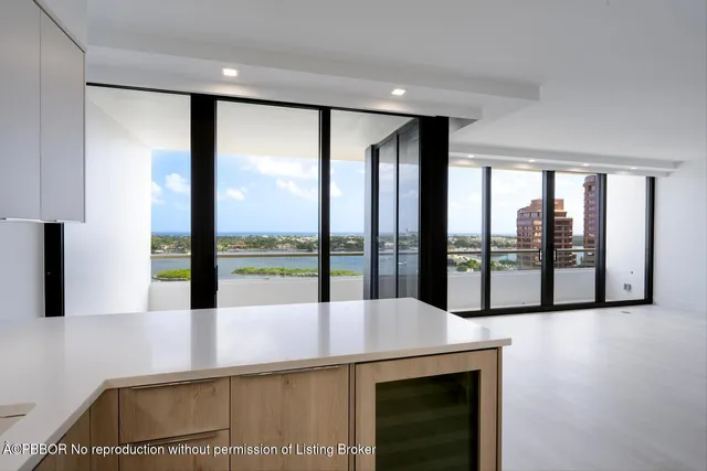 a large white kitchen with kitchen island a sink stainless steel appliances and cabinets