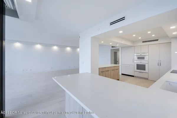 a view of kitchen with stainless steel appliances kitchen island granite countertop a table and chairs