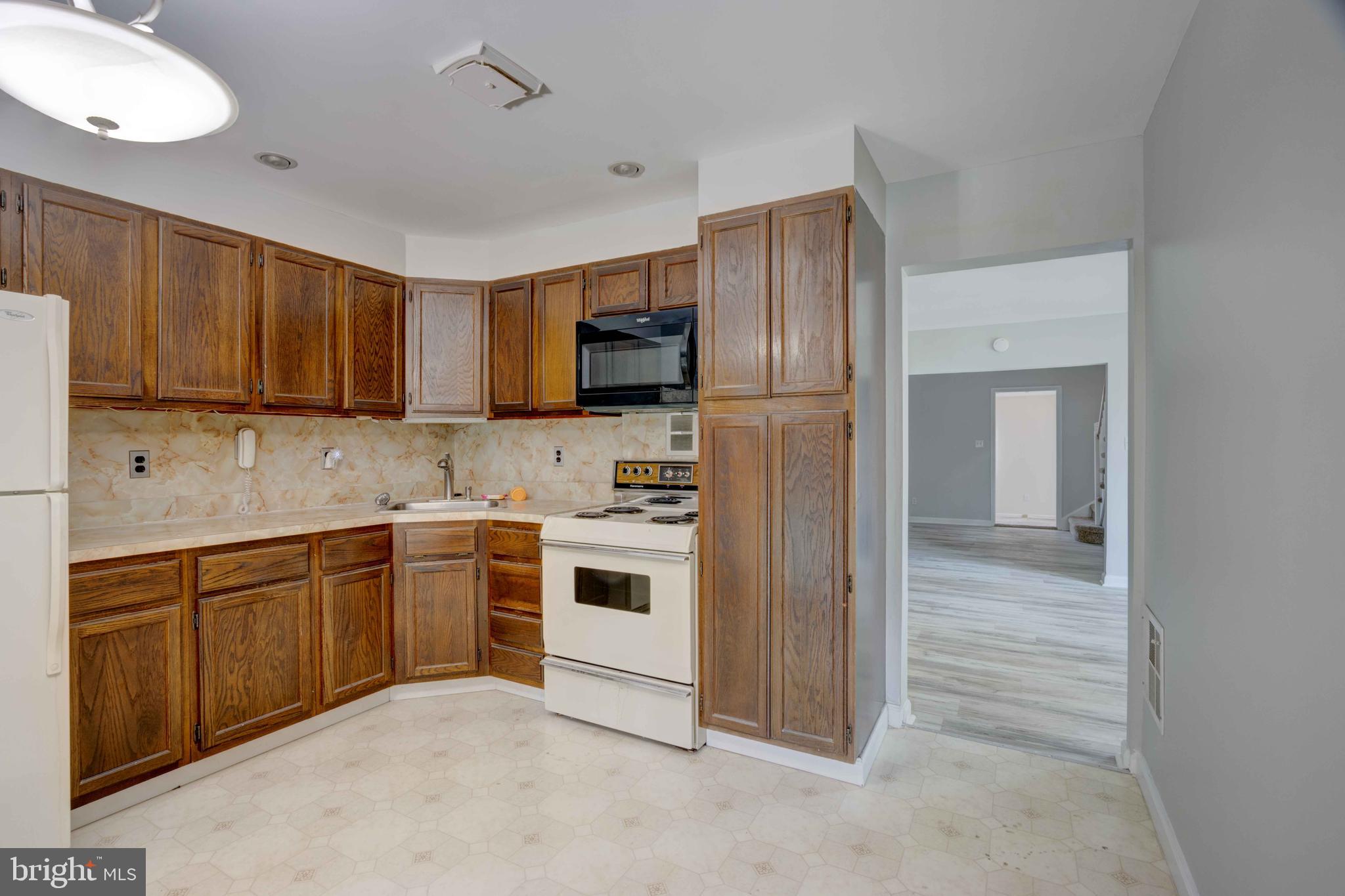 625 Hammonds Lane Baltimore, MD 21225 - Photo 13 of 40 a kitchen with stainless steel appliances granite countertop a refrigerator and a stove top oven