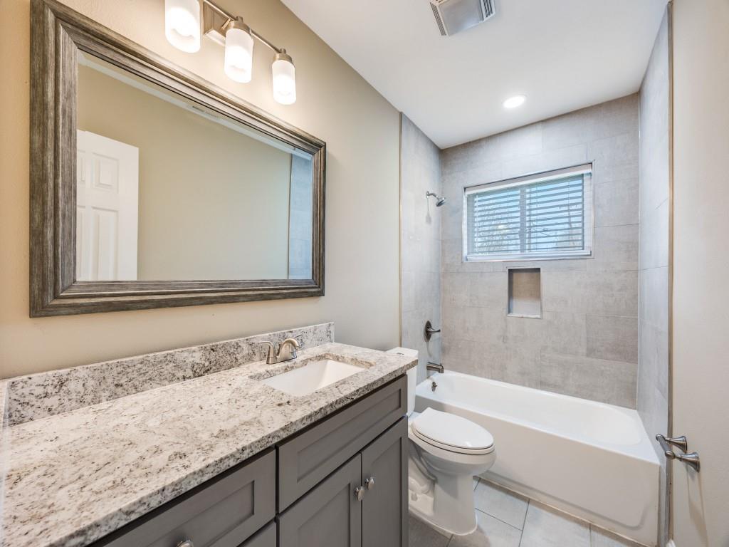 8911 Angleton Place Dallas, TX 75243 - Photo 11 of 12 a bathroom with a granite countertop sink toilet and shower