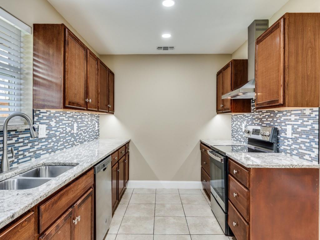 8911 Angleton Place Dallas, TX 75243 - Photo 5 of 12 a kitchen with stainless steel appliances granite countertop a sink stove and cabinets