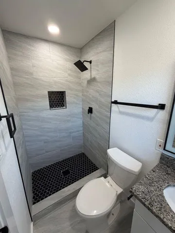 a bathroom with a toilet and a shower