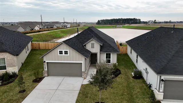 an aerial view of a house with a garden and lake view
