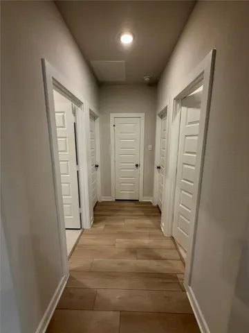 a view of a hallway with wooden shelves
