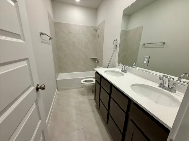 a bathroom with a sink a toilet a mirror and shower