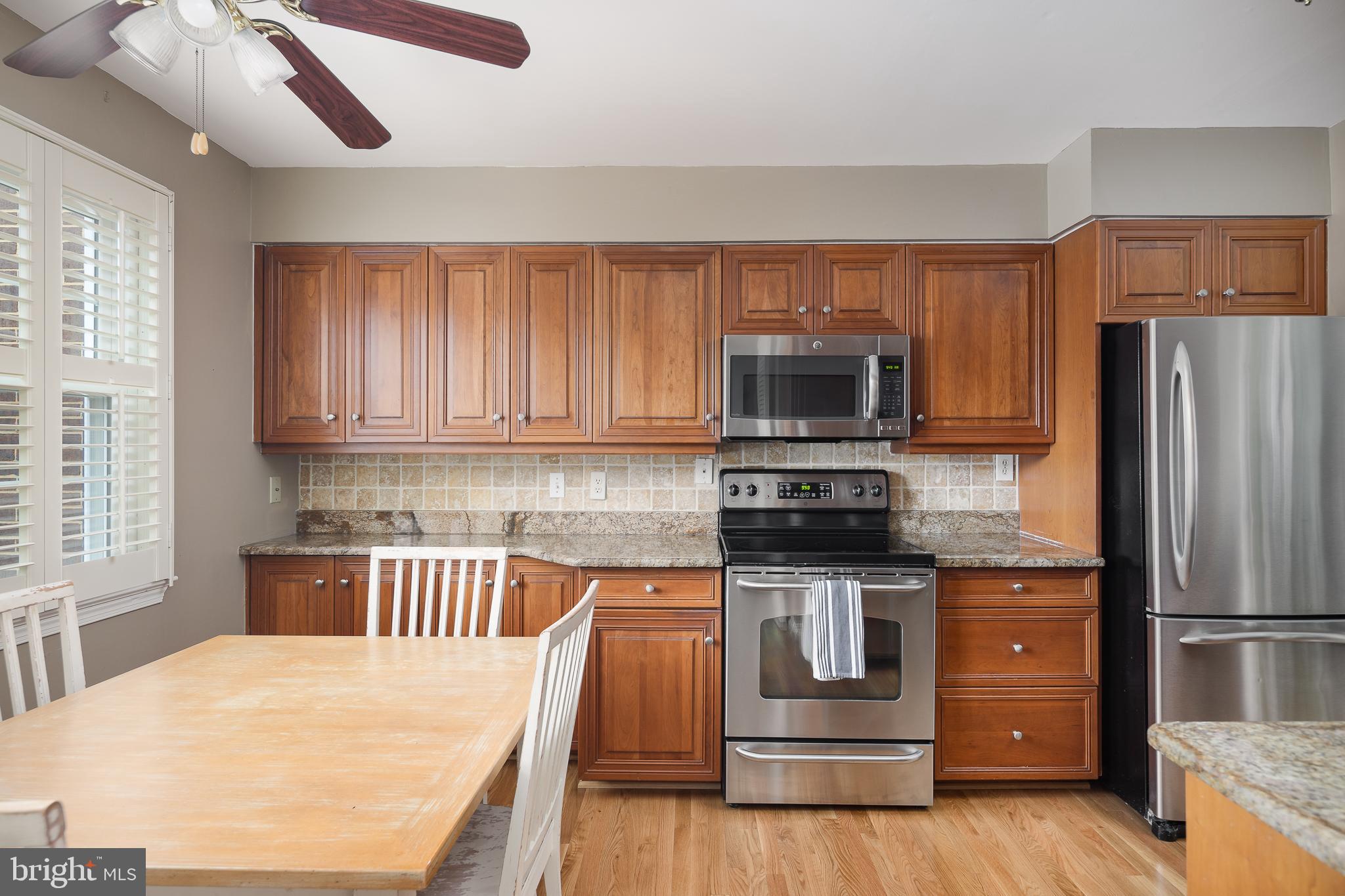 6311 Golf Course Square Alexandria, VA 22307 - Photo 3 of 39 a kitchen with stainless steel appliances wooden cabinets and a stove top oven