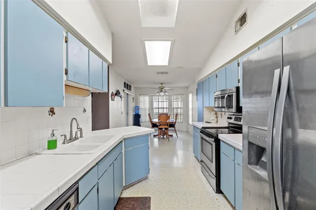 a kitchen with stainless steel appliances a sink stove and refrigerator